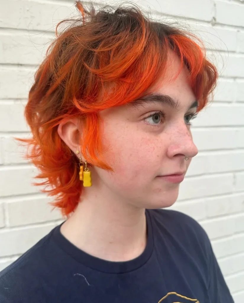 Short curly micro shag with baby bangs in bright orange