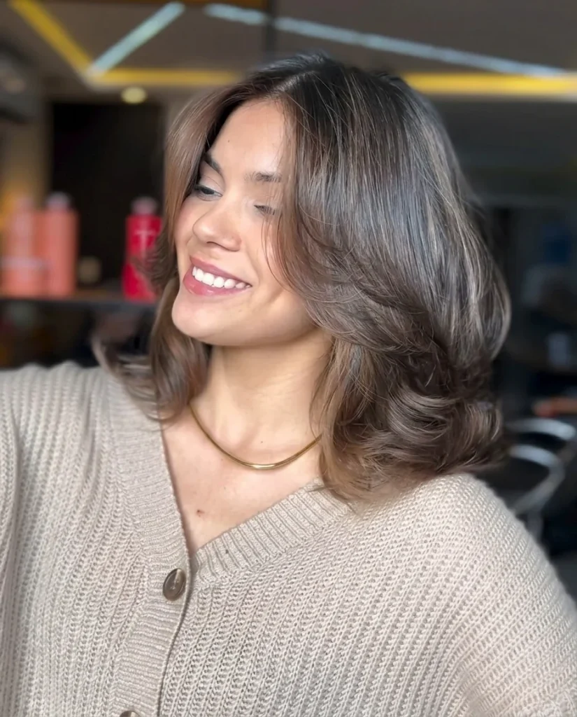 Dramatic butterfly cut with shoulder-length layers, flipped ends and caramel highlights