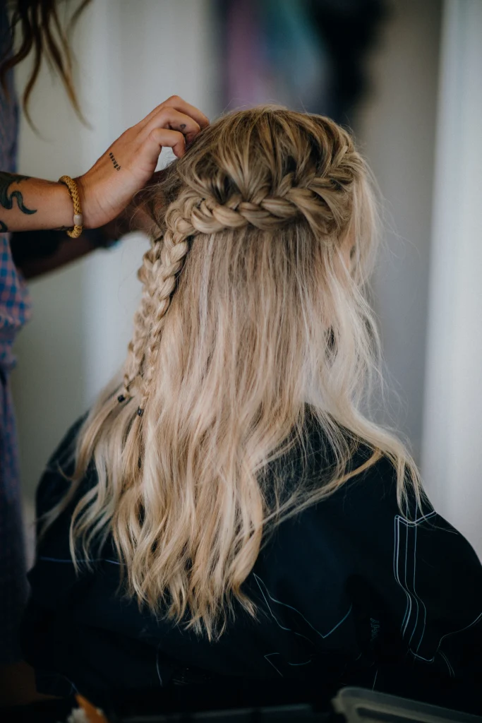 Long thick hair styled in a classic three-strand braid, smooth crown, defined woven sections, natural shine, neutral background, rear view with soft daylight.