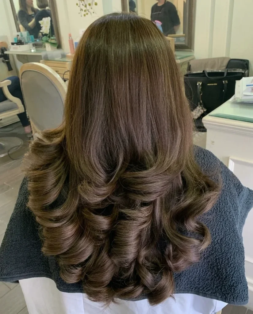 back view of medium-brown mocha hair with polished, voluminous barrel curls at the ends, salon setting