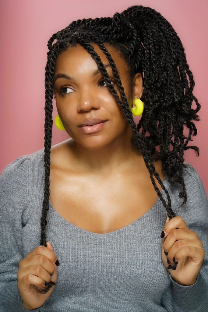 Long hair arranged in two defined rope twists, glossy medium brown strands, clear twisted texture, relaxed bohemian style, natural daylight, back view.