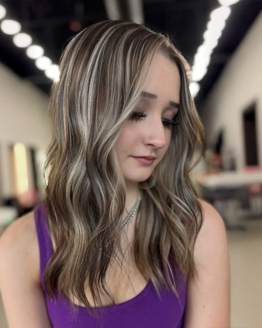 Long wavy hair with chunky platinum highlights framing the face